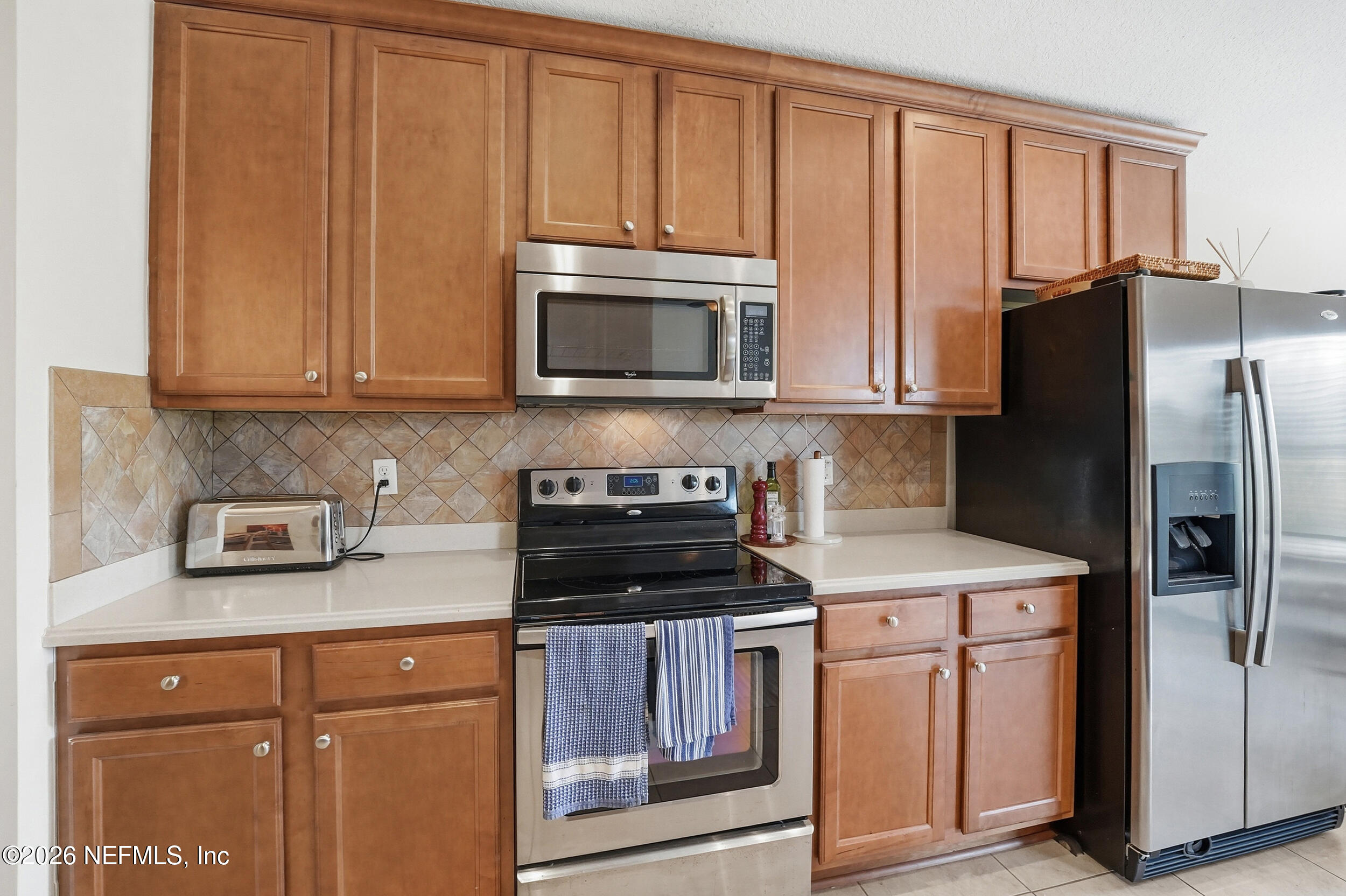 374 Porta Rosa Circle St. Augustine, FL 32092 - Photo 16 of 47 a kitchen with granite countertop a refrigerator stove and microwave