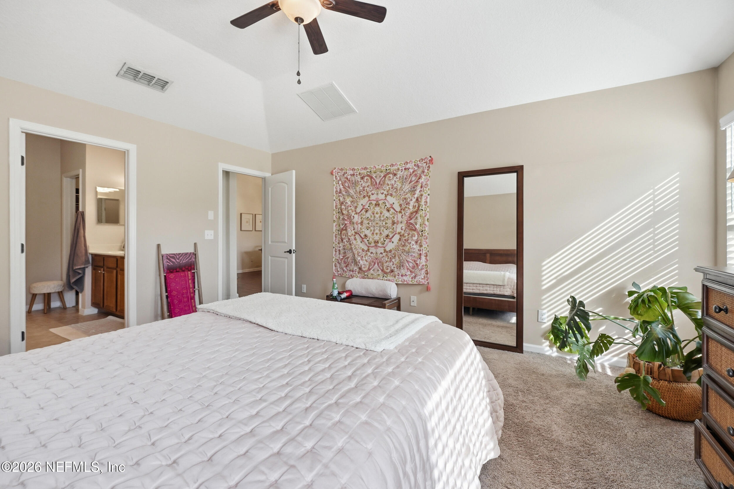 374 Porta Rosa Circle St. Augustine, FL 32092 - Photo 19 of 47 a bedroom with a large bed and a chandelier