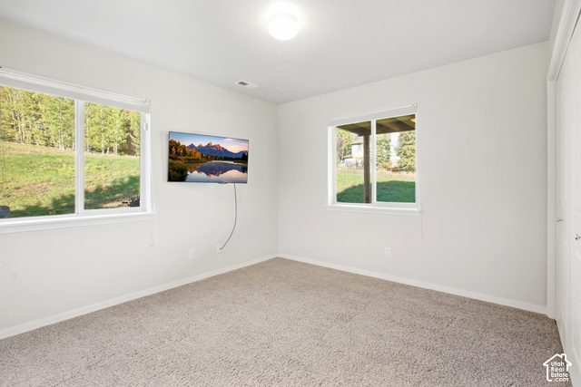 7396 Brook Hollow Loop Road Park City, UT 84098 - Photo 26 of 60 Bright room with two windows, light-colored carpeting, and a flush-mount ceiling light