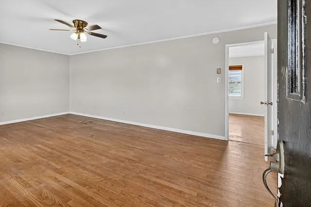 wooden floor in an empty room with a window