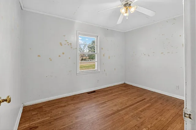 an empty room with windows and fireplace