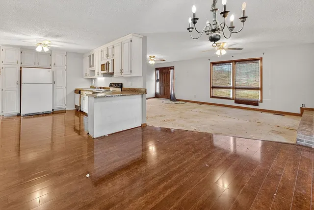 a front view of residential houses with yard and trees