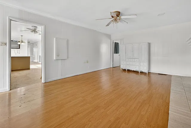a view of a livingroom with wooden floor and a fireplace