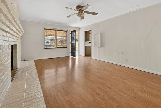 wooden floor fireplace and windows in an empty room