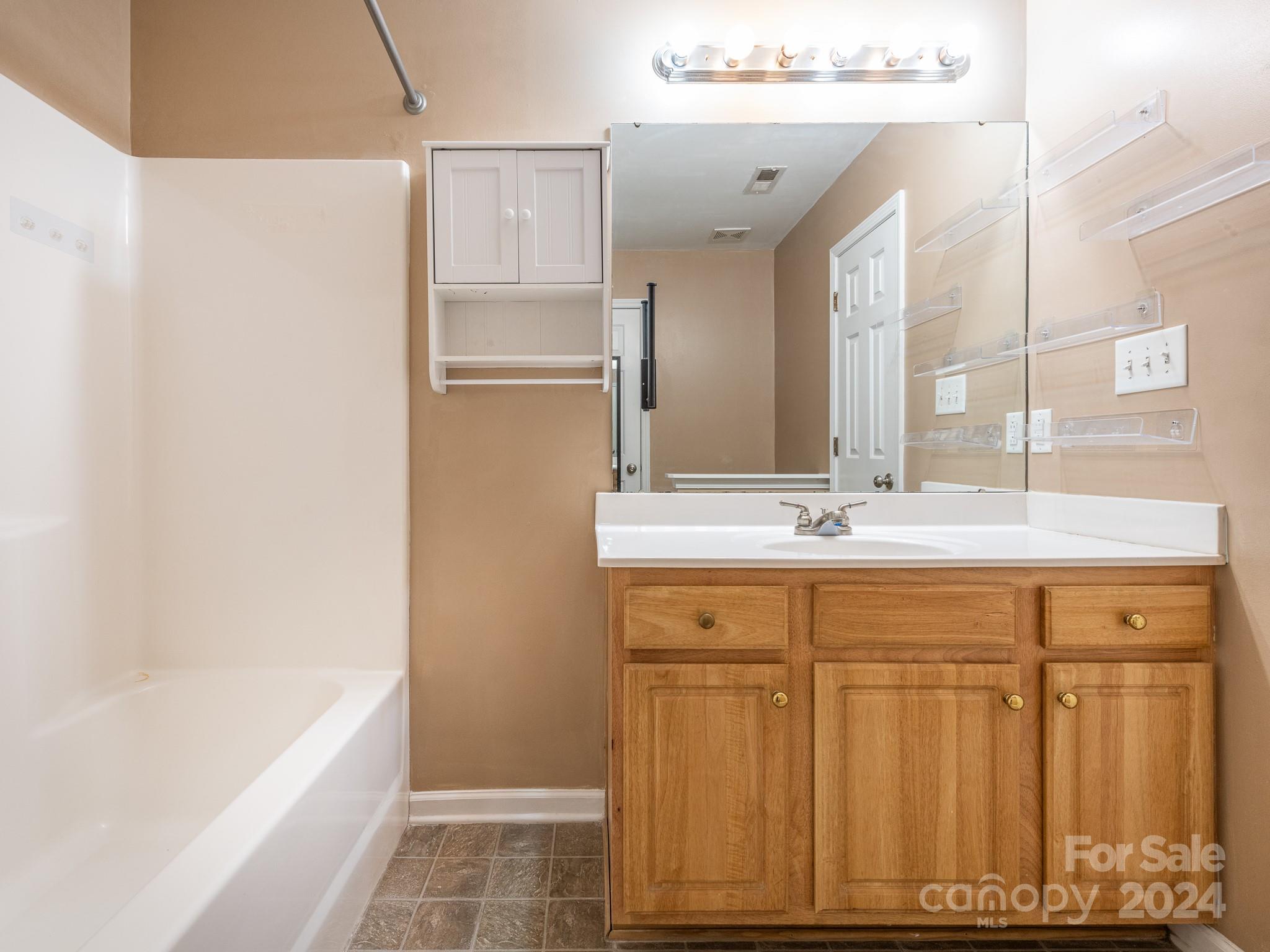 401 Funderburk Road Wingate, NC 28174 - Photo 24 of 36 a bathroom with a double vanity sink a mirror and a bathtub