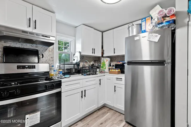a kitchen with a refrigerator and a stove top oven