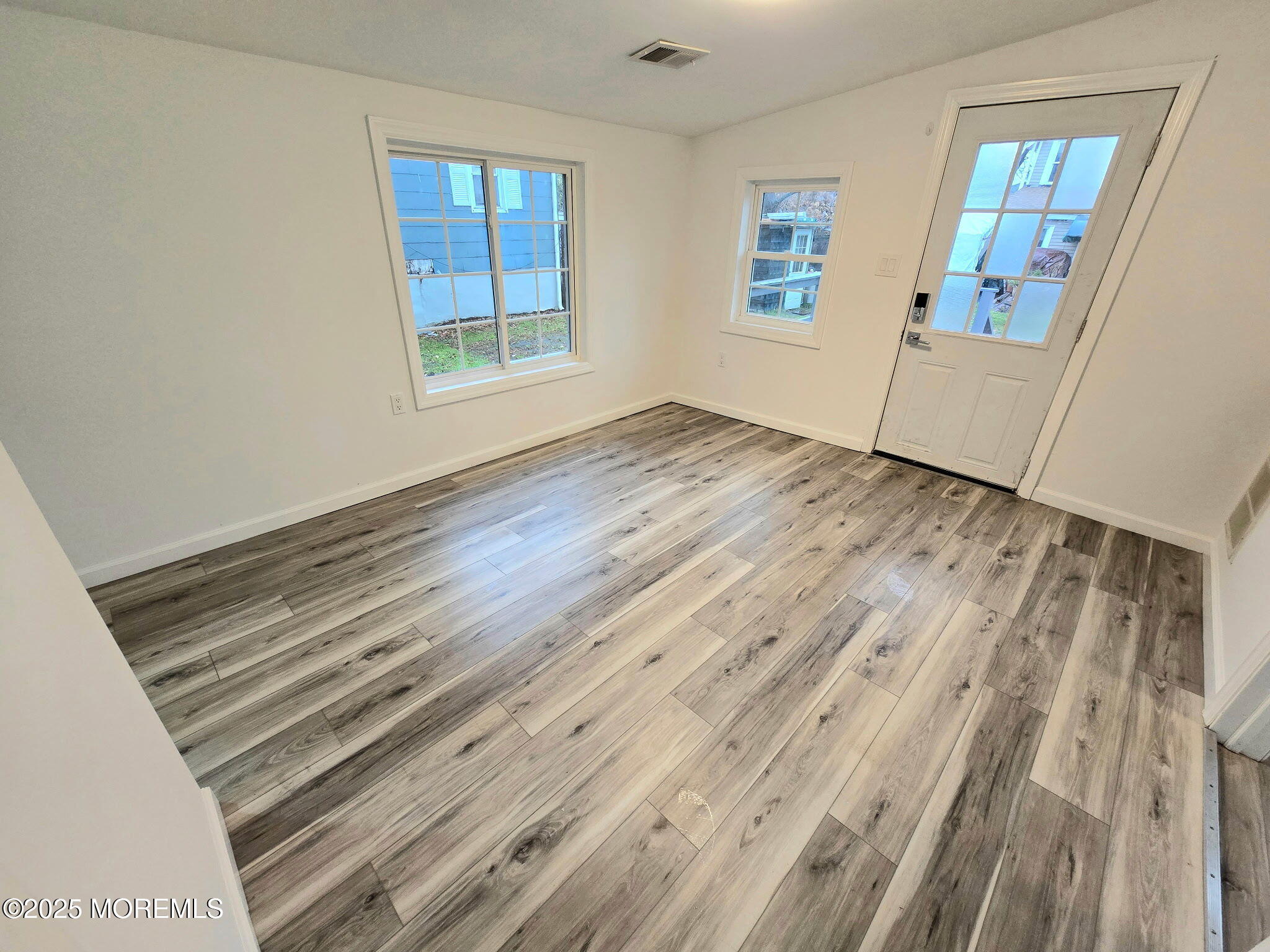 912 Sunset Avenue, Unit REAR Asbury Park, NJ 07712 - Photo 3 of 8 a view of an empty room with wooden floor and a window