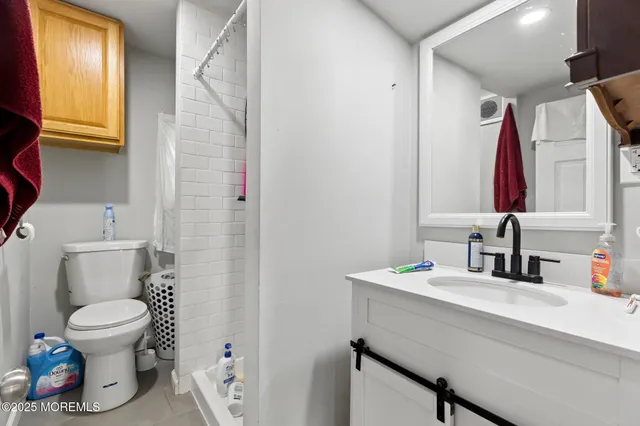 a bathroom with a sink vanity mirror and toilet