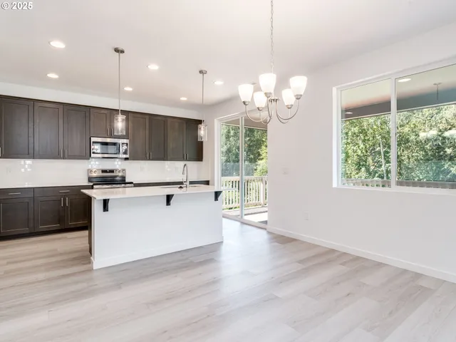 a large white kitchen with lots of counter space and a chandelier