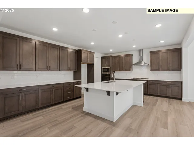 a large kitchen with stainless steel appliances sink a microwave and cabinets