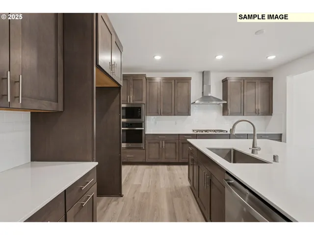 a kitchen with kitchen island granite countertop a sink stainless steel appliances and cabinets