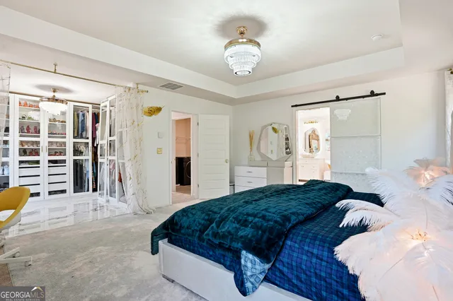a bedroom with a large bed and a chandelier