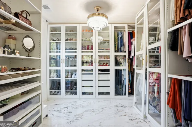 a view of walk in closet with clothes and shoes
