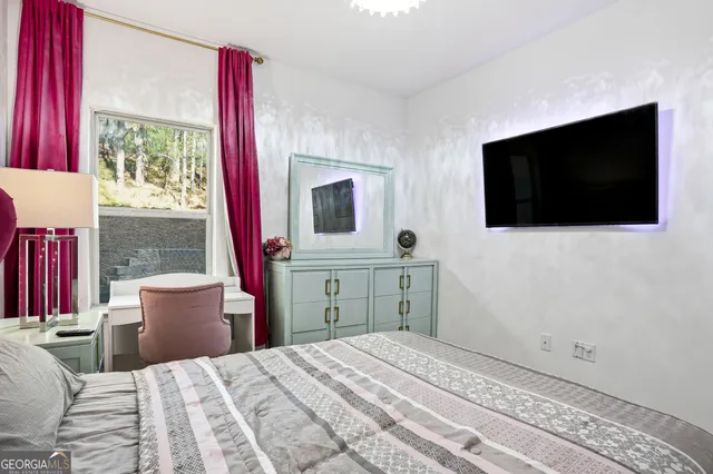 a bedroom with a bed and a flat screen tv