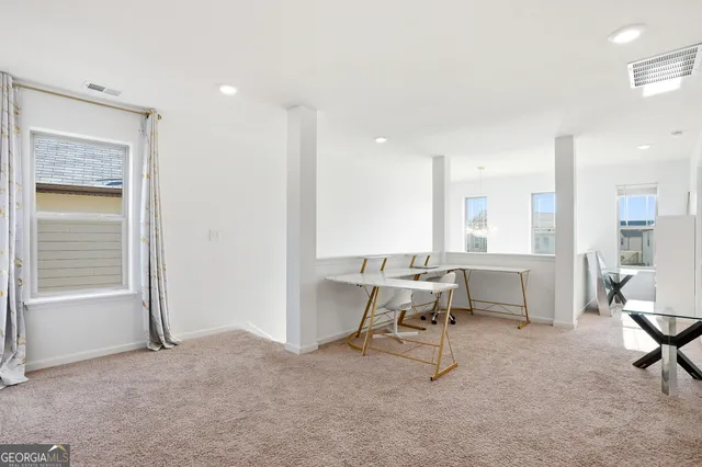 a view of a workspace with furniture and a window