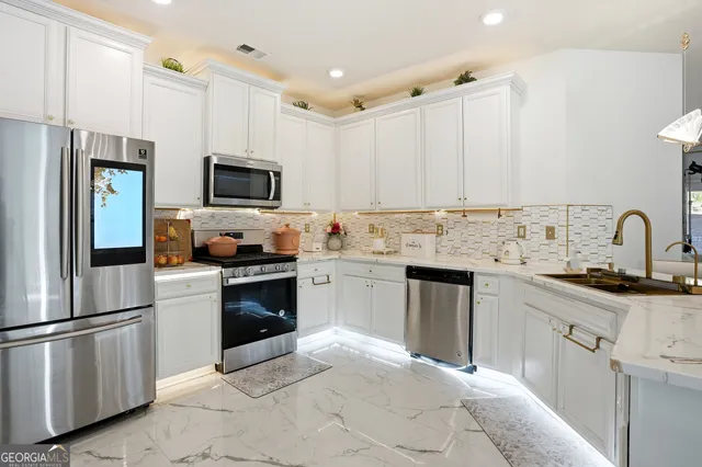 a kitchen with cabinets stainless steel appliances and a counter space