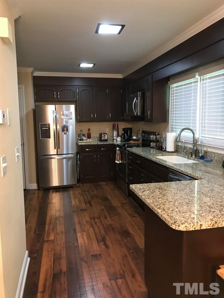 7819 Breckon Way Raleigh, NC 27615 - Photo 3 of 5 Granite counters, refinished cabinets, and laminate flooring make this roomy kitchen special.