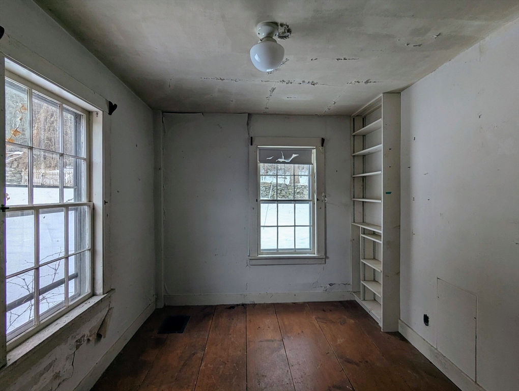 49 Enfield Road Pelham, MA 01002 - Photo 17 of 34 an empty room with wooden floor and windows