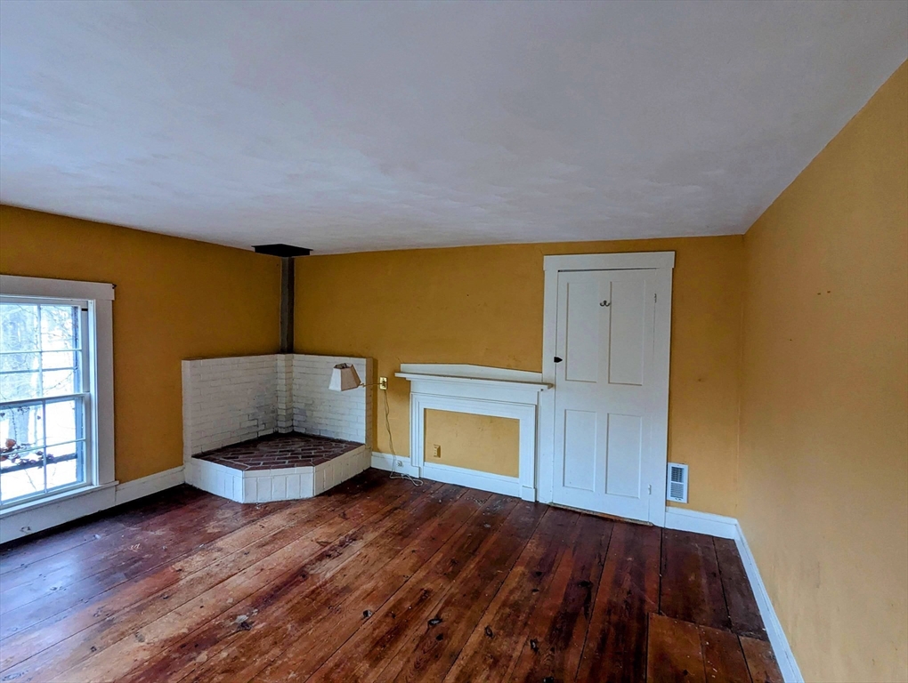 49 Enfield Road Pelham, MA 01002 - Photo 23 of 34 a living room with a fireplace and wooden floor
