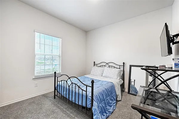 a bedroom with a bed a table and chair