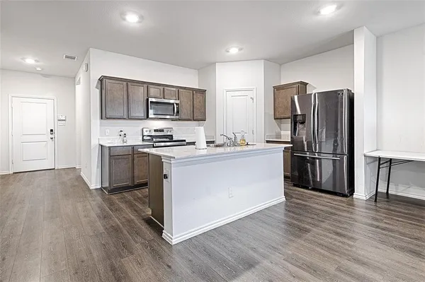 a kitchen with stainless steel appliances a refrigerator stove and microwave