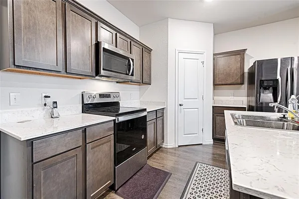 a kitchen with stainless steel appliances granite countertop a sink stove and refrigerator