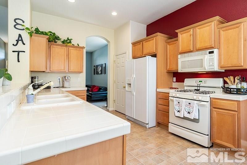 1445 Hagar Road Reno, NV 89506 - Photo 9 of 23 a kitchen with granite countertop a sink stove and refrigerator