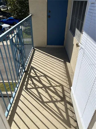 a view of a balcony with a couple of cars parked in front of building