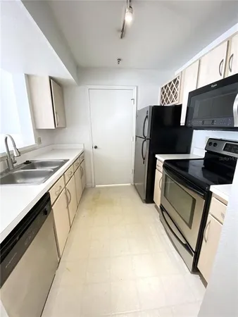 a kitchen with stainless steel appliances a stove microwave and sink