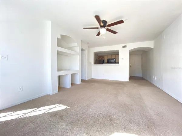 a view of a big room with wooden floor and windows