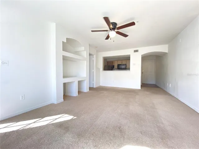 a view of a big room with wooden floor and windows