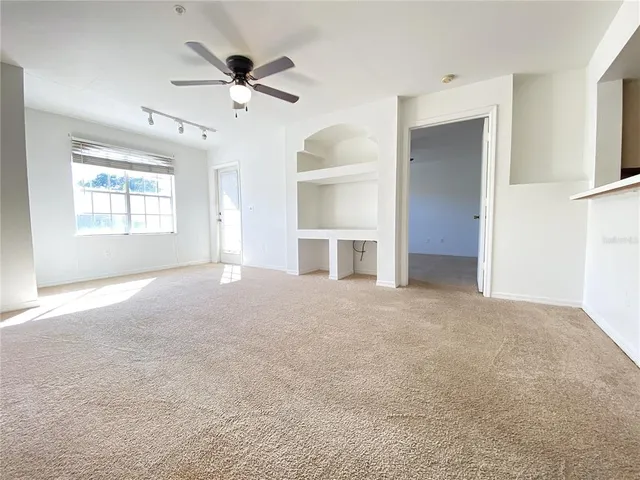 a view of a livingroom with a ceiling fan and window