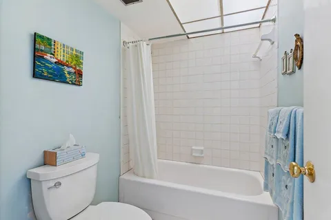 a bath room with a toilet a bath tub and a shower