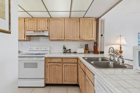 a kitchen with stainless steel appliances granite countertop a sink a stove and cabinets