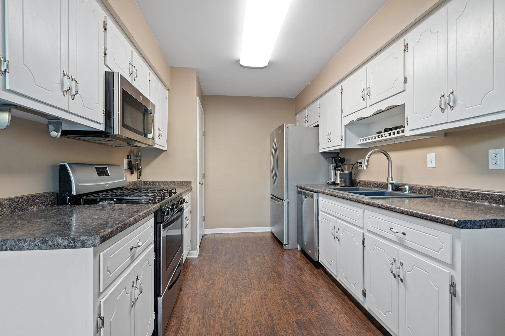 778 Lake Road, Unit 778 New Lenox, IL 60451 - Photo 5 of 16 a kitchen with granite countertop a sink dishwasher stove and cabinets with wooden floor