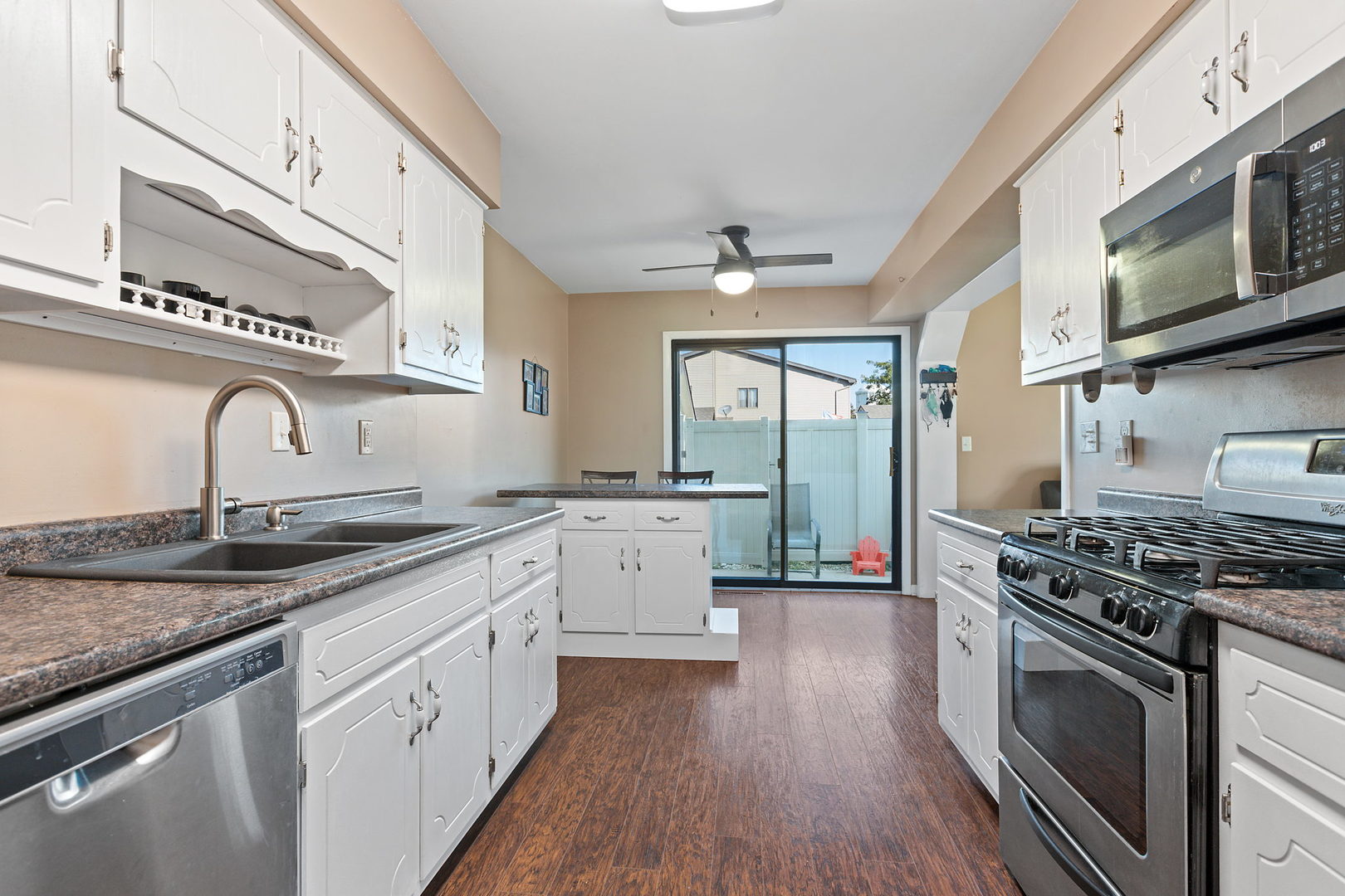 778 Lake Road, Unit 778 New Lenox, IL 60451 - Photo 6 of 16 a kitchen with granite countertop a sink cabinets stainless steel appliances and a counter space
