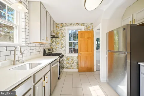 a kitchen with a refrigerator sink and cabinets