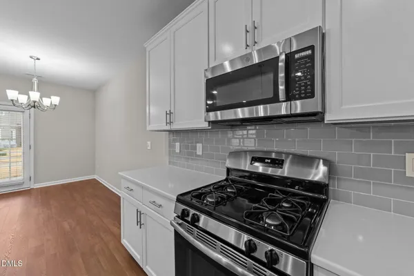 a kitchen with stainless steel appliances a stove a microwave and cabinets