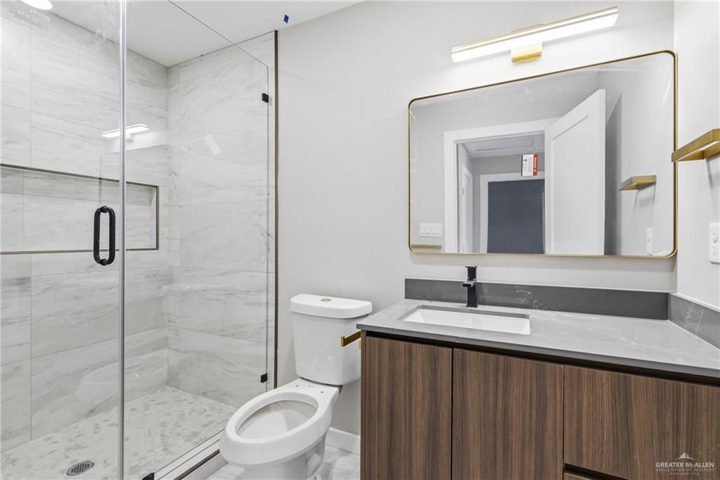 2206 Corales Street Mission, TX 78573 - Photo 13 of 19 a bathroom with a double vanity sink toilet and a mirror