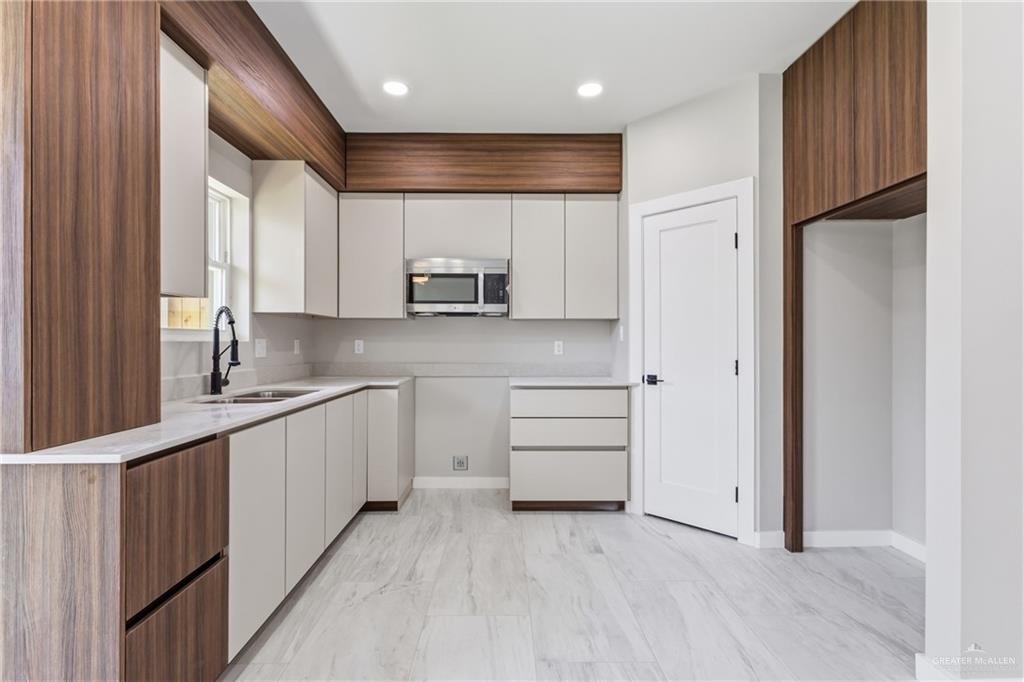 2206 Corales Street Mission, TX 78573 - Photo 4 of 19 a kitchen with kitchen island granite countertop a sink cabinets and stainless steel appliances