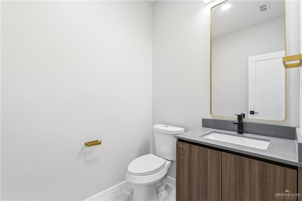2206 Corales Street Mission, TX 78573 - Photo 5 of 19 a bathroom with a granite countertop toilet and a sink