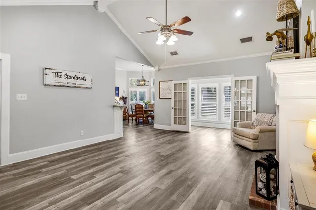 a dining room with furniture a chandelier and wooden floor