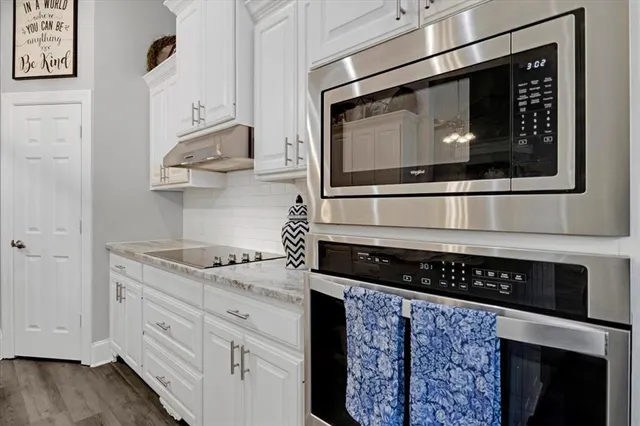 a spacious bathroom with a granite countertop double vanity sink a mirror and a shower