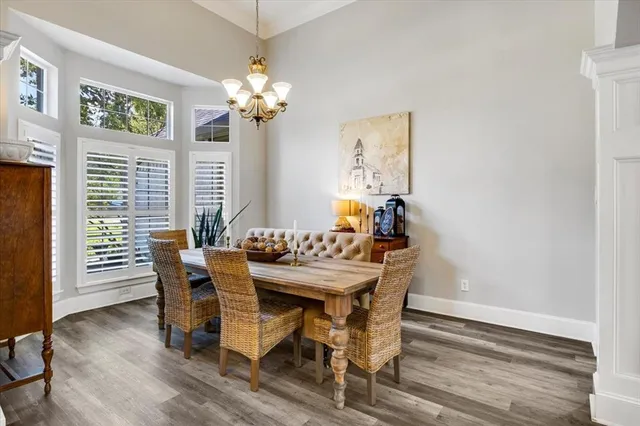 a view of an empty room with wooden floor fireplace and a window