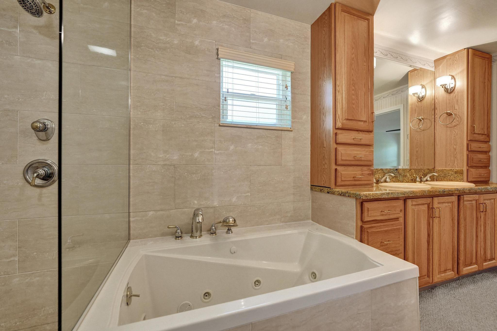 10896 Waterberry Court Boca Raton, FL 33498 - Photo 28 of 34 a bathroom with a tub sink and mirror