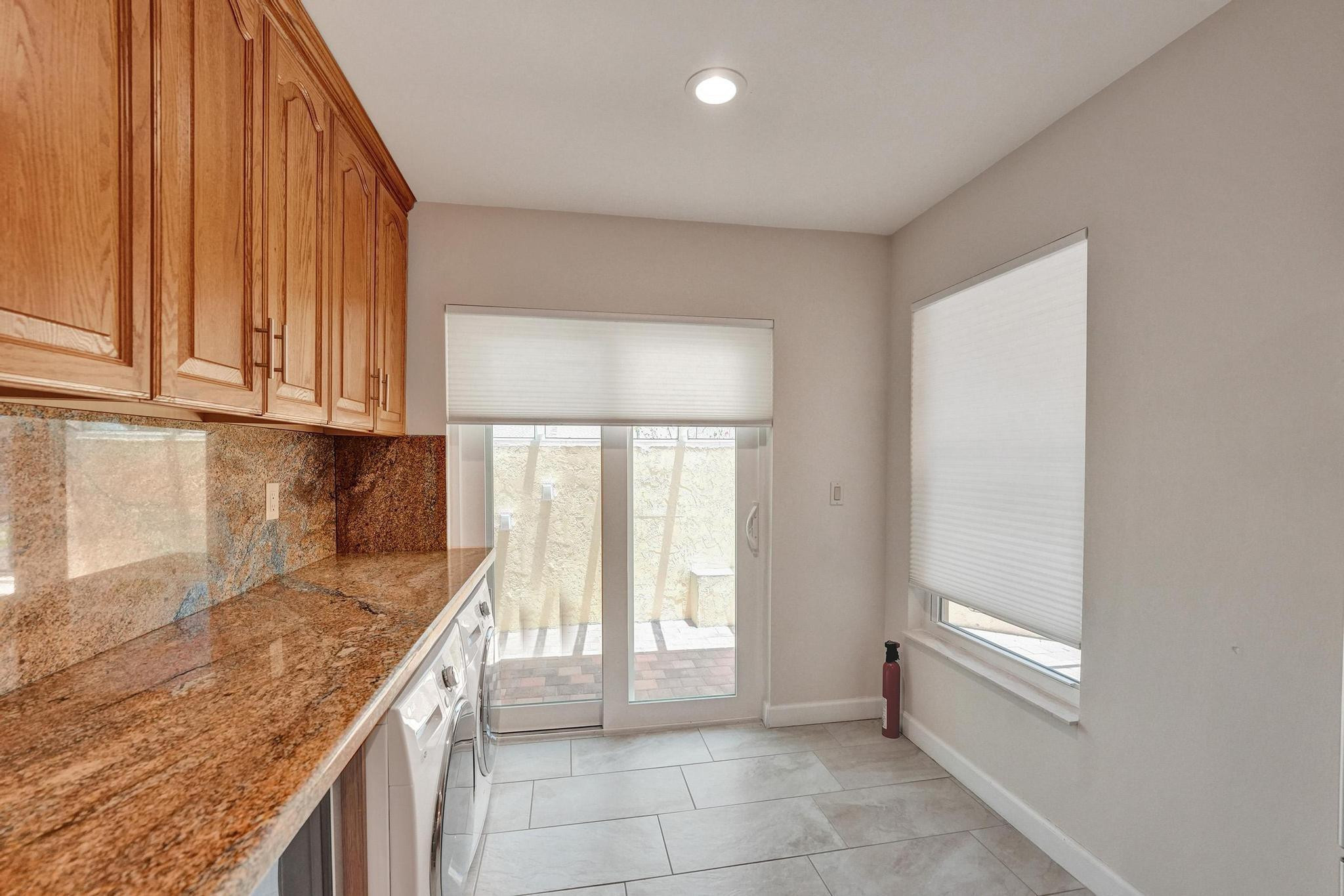 10896 Waterberry Court Boca Raton, FL 33498 - Photo 10 of 34 a kitchen with granite countertop a sink a stove and cabinets