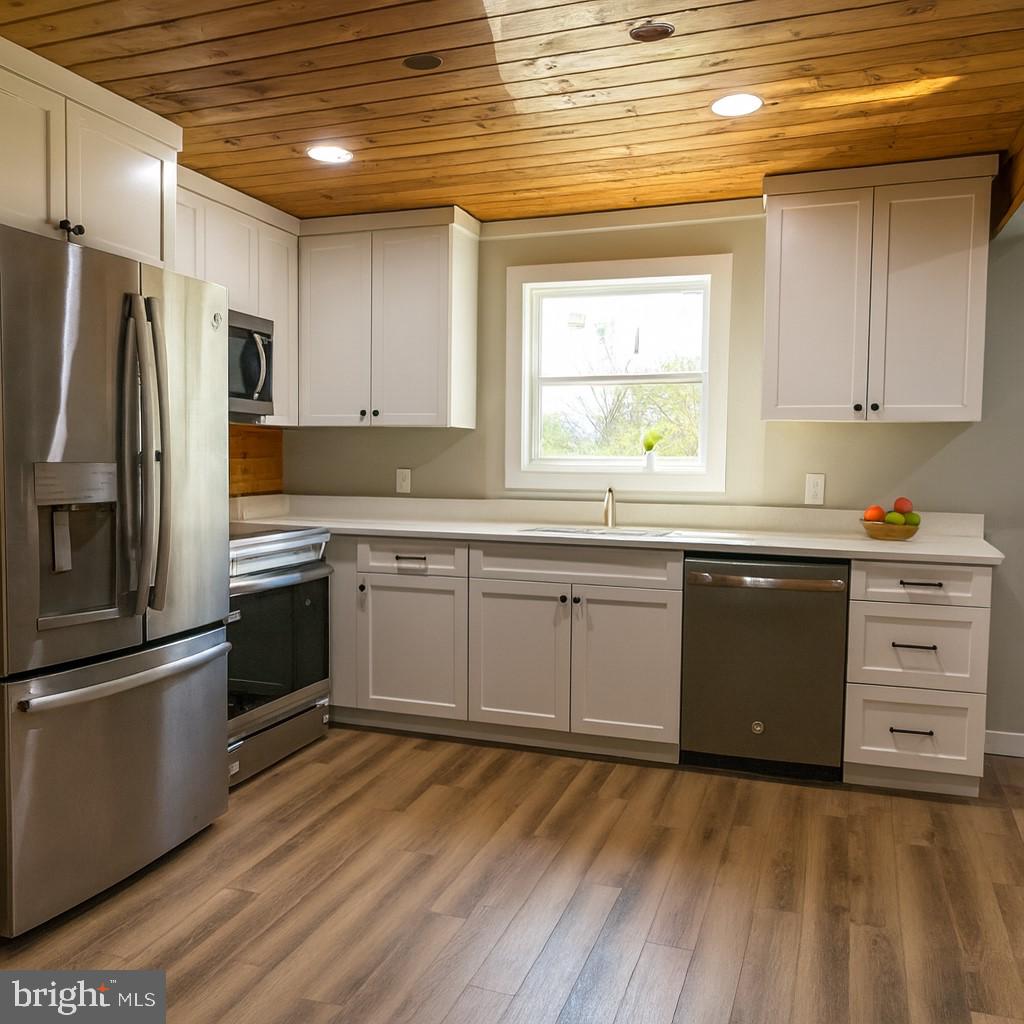 7699 Hedgesville Road Hedgesville, WV 25427 - Photo 15 of 47 a kitchen with stainless steel appliances a stove a sink and a refrigerator