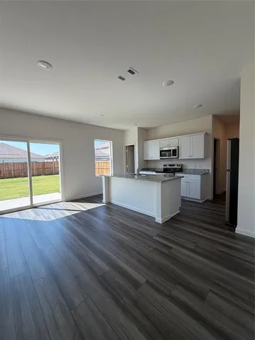 a kitchen with granite countertop a stove sink and cabinets