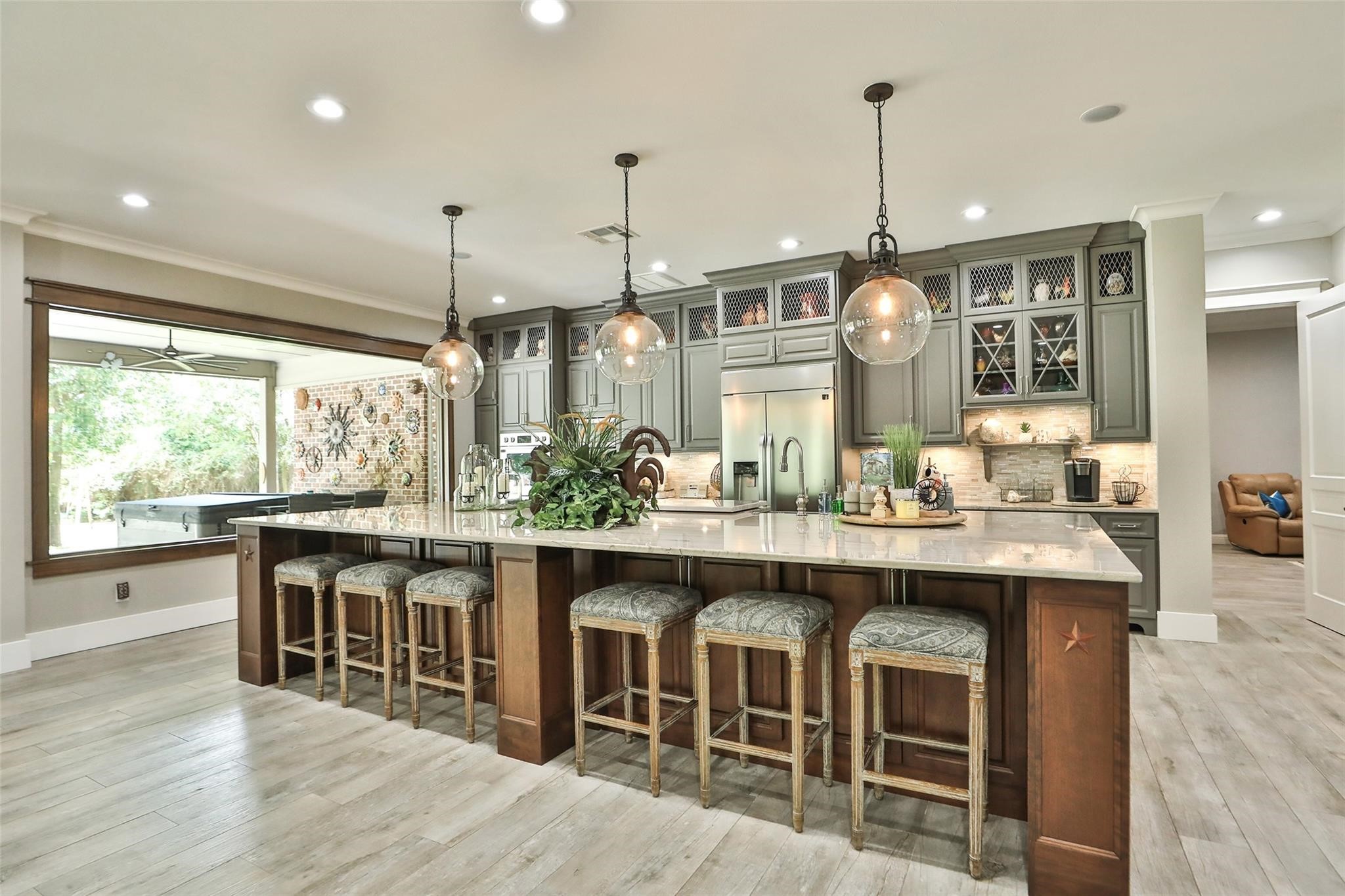 12126 Zion Road Tomball, TX 77375 - Photo 17 of 45 Stunning custom kitchen with LG Studio appliances, Kohler farmhouse sink, Quartzite counters, 15' by 7' solid cherry island, custom maple wood cabinets, dovetailed drawers, Pottery Barn pendant lighting, breakfast bar with plenty of storage under the island.