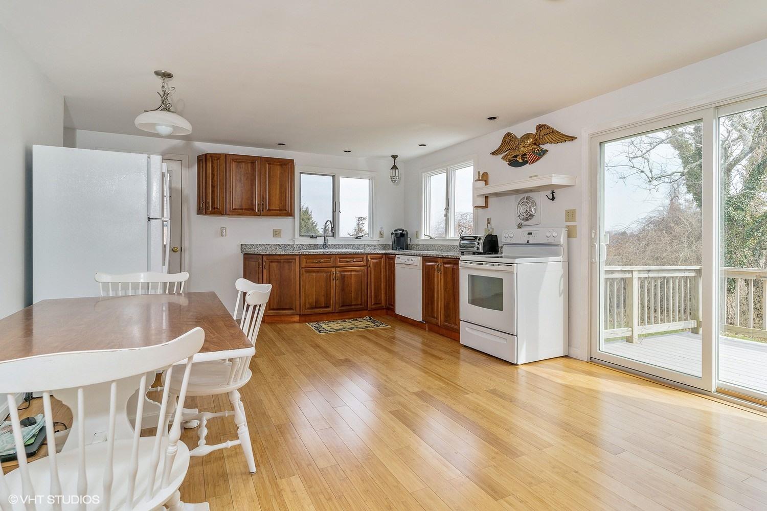 151 Harbor Point Road Cummaquid, MA 02675 - Photo 4 of 14 a kitchen with a table chairs microwave and cabinets